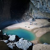 Hang En Cave  So here it is - the worlds third biggest cave (or at least part of it). On the sand benche, our porters are already building up the campsite and start cooking for dinner...